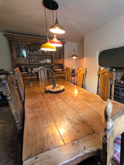 Large Dining table and Chairs with log burner and oak beams on ceiling